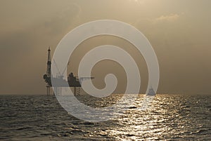 Oil rig with Standby boat in the sunset photo