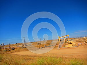 Oil rigs/oil drilling equipment in a field in a california valley