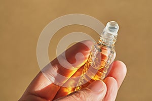 Oil roller perfume on a beige background.