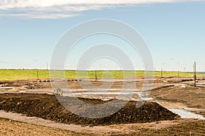 Oil sands refinery industry landscape, brown ground and blue sky