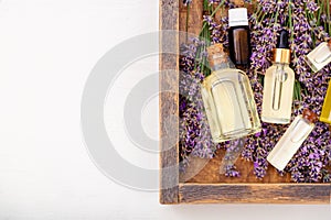Oil serum oils on lavender flowers in wooden box. Lavender essential oil, serum, body butter, massage oil, liquid. Flat lay copy