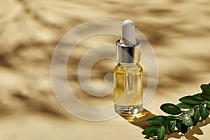 Oil for spa treatment in glass bottle on beige background