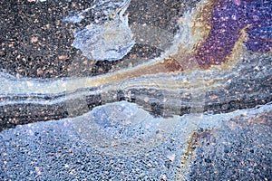 Oil Spill on Asphalt, Colorful Gasoline Fuel Stains on Asphalt Road as Texture or Background.