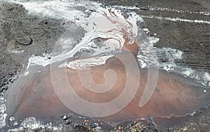 Oil spills on the background of puddles, an abstract concept of gasoline pollution of nature