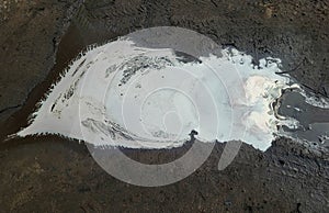 Oil spills on the background of puddles, an abstract concept of gasoline pollution of nature