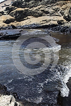 oil spills on the beaches of the pacific ocean with contaminated rocks of repsol company in lima peru in the year 2022