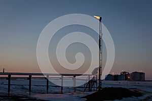 Oil stack burning at the top at dusk in winter