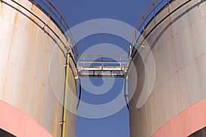 Oil storage tank with metal bridge and stairs