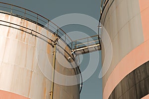 Oil storage tank with metal bridge and stairs