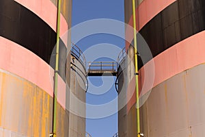 Oil storage tank with metal bridge and stairs