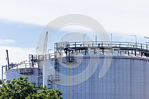 Oil storage tanks with blue sky background, Industrial tanks for petrol and oil, White fuel storage tank against blue sky