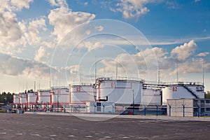 Oil storage tanks terminal on a summer day. Several large barrels of oil