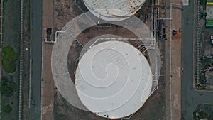 Oil storage tanks top view. Drone flying industrial facility with fossil fuel