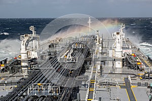 Oil tanker deck during storm with rainbow