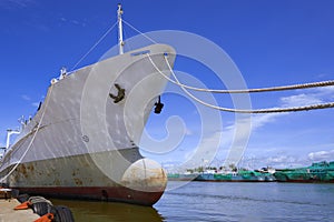 Oil tanker moored at harbor against blue sky background