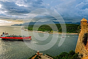 Oil tanker passes the San Pedro de La roca fort walls and tower,