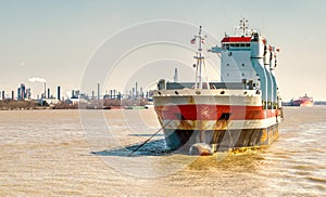 Oil tanker ship anchored in front of an industrial area