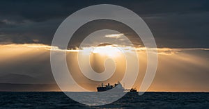 Oil tanker ship in the ocean. Sunset sky.