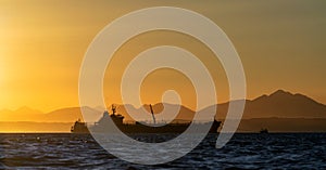 Oil tanker ship in the ocean. Sunset sky. Early in the morning, the sunrise. South Africa. Mossel Bay