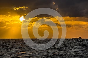 Oil tanker ship at sea on a background of sunset sky