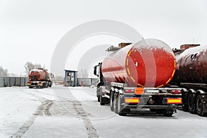 An oil tanker truck with a semitrailer-tanker truck drives through the checkpoint from the territory of the motor transport base