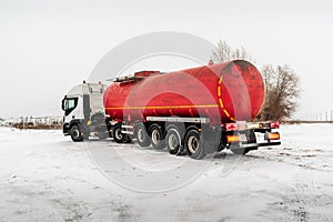 Oil tanker truck with a tank semi-trailer on a winter road