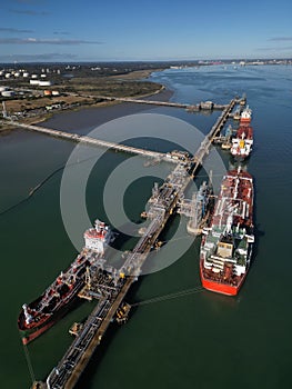 Oil tankers and pipelines at Fawley oil terminal aerial vertical