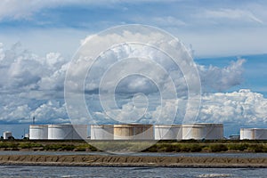 Oil tanks in a row under blue sky, Large white industrial tank f