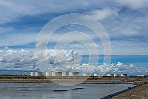 Oil tanks in a row under blue sky, Large white industrial tank f