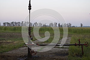 Oil valves and piping. production wellhead. A natural oil well. Horizontal view of a wellhead with valve armature. Oil and gas