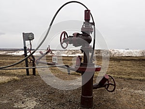 Oil valves and piping. production wellhead. A natural oil well. Horizontal view of a wellhead with valve armature. Oil and gas