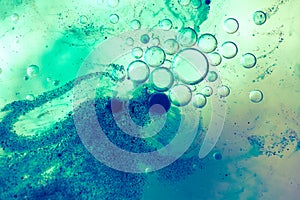 Oil, water and blue pigment particles abstract background