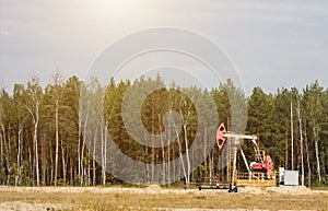 Oil well for the extraction of oil and gasoline and gas on the background of the forest, the production of fuel-combustible