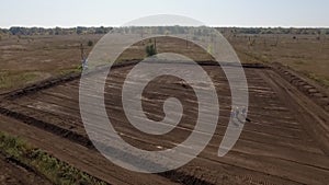 Oil well in field, workers are going to it, aerial view in summer day