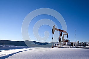 Oil well pumpjack mountain snow