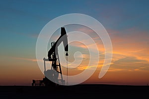 Oil Well Silhouetted Against Prairie Sunset