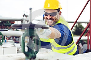 Oil worker closes the valve on the oil pipeline