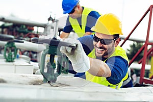 Oil worker closes the valve on the oil pipeline