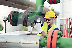 Oil worker closes the valve on the oil pipeline