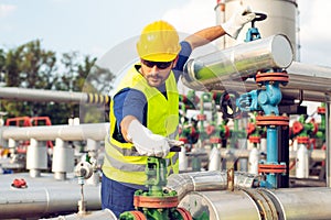 Oil worker closes the valve on the oil pipeline