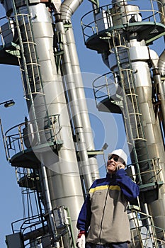 Oil worker in front of oil and fuel towers