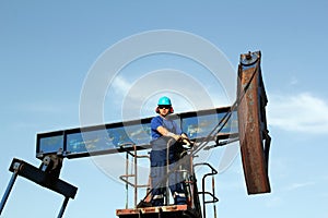 Oil worker standing at pump jack