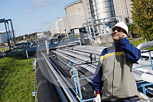 Oil worker talking in phone inside refinery