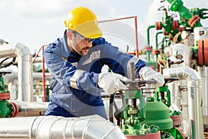 Oil worker is turning valve on the oil pipeline