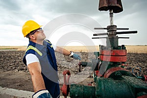 Oil worker is turning valve on the oil pipeline. Oil and Gas Industry.
