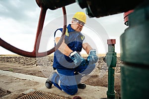 Oil worker is turning valve on the oil pipeline. Oil and Gas Industry.