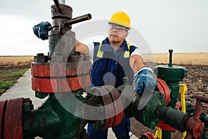 Oil worker is turning valve on the oil pipeline. Oil and Gas Industry.