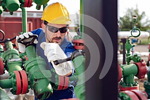 Oil worker turning valve on oil rig