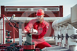 Oil worker turning valve on oil rig