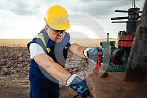 Oil worker is turning valve on the oil pipeline. Oil and Gas Industry.